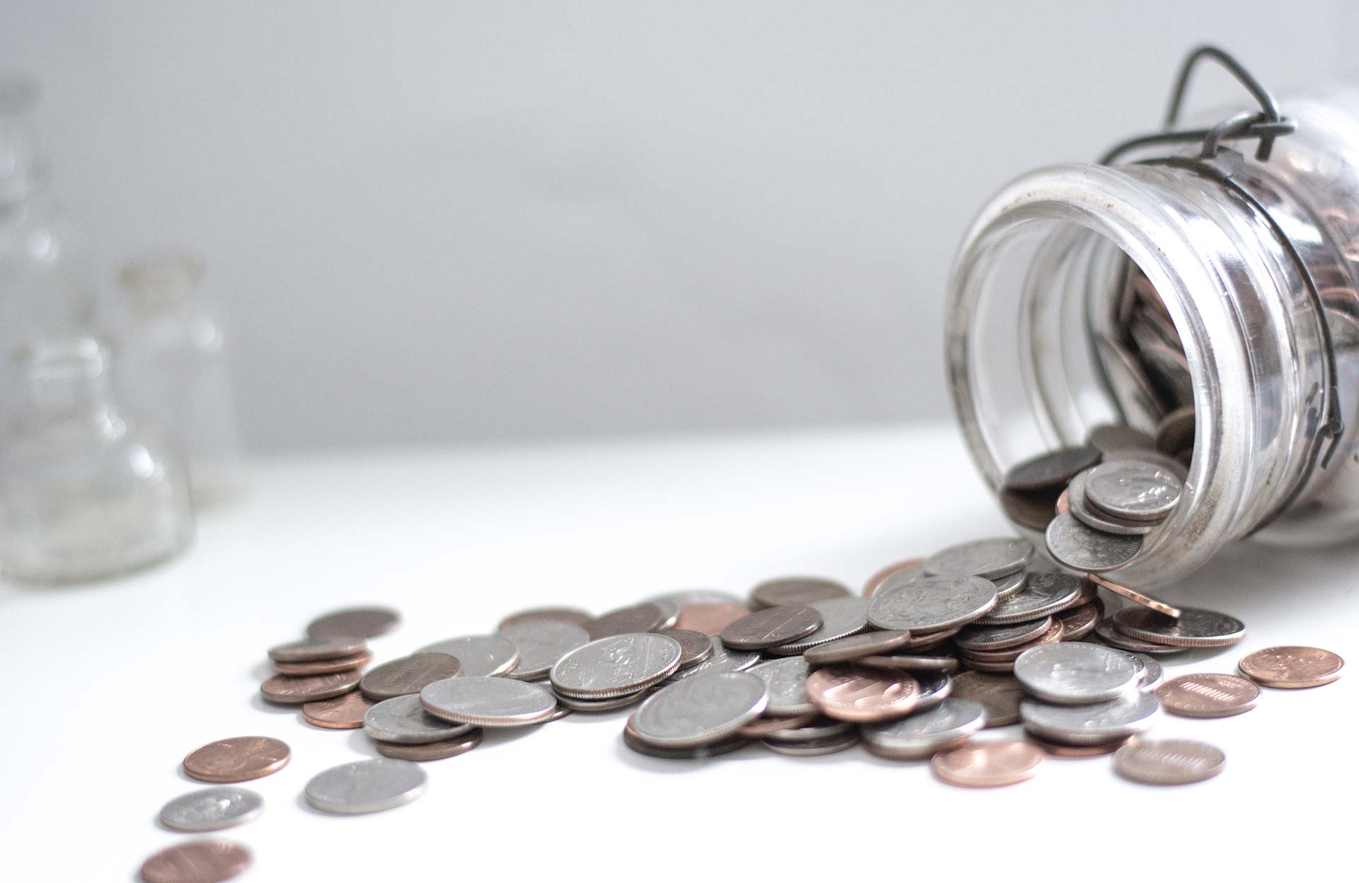 Jar with coins spilling out to illustrate the fees for a wedding ceremony