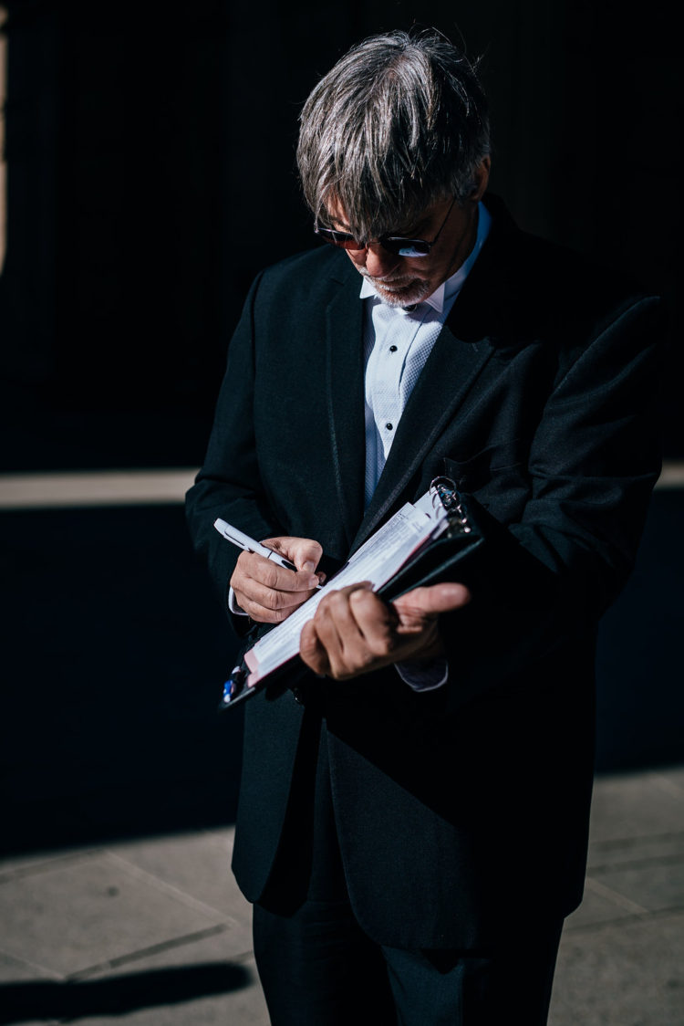 A photo of the officiant signing the marriage license just after the ceremony at Palace of Fine Arts San Francisco CA