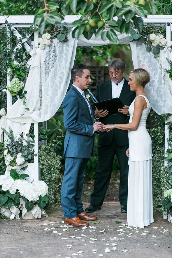 A photo of the groom putting the ring on his bride during the wedding ceremony