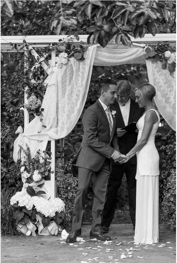 a black and white photo of the groom breaking the glass under the chuppah. at an Interfaith Wedding Ceremony held at the Marin Art & Garden Center in Ross, Marin County CA