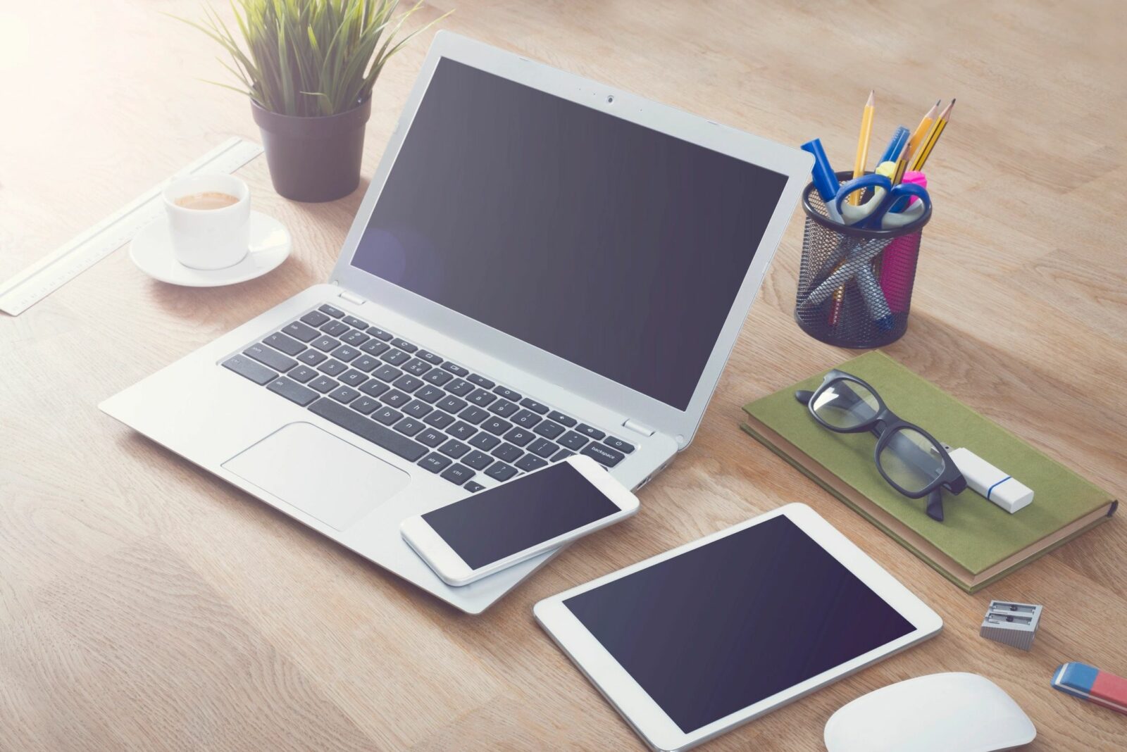 a photo of a Computer, a mobile phone, and an iPad, notebook and other items on a desk