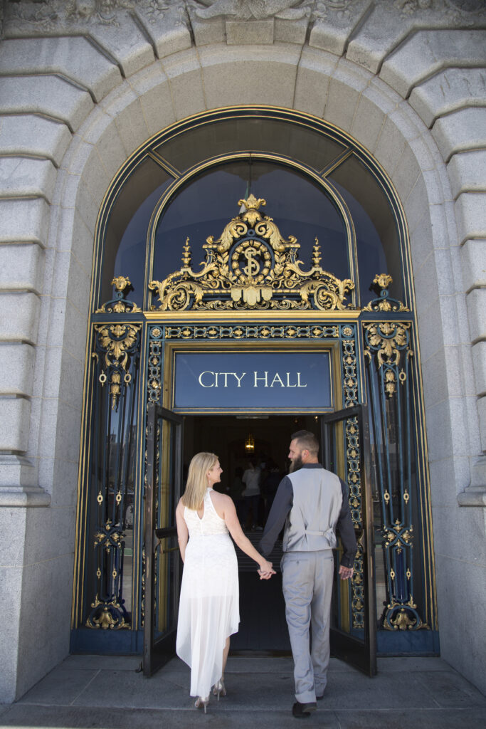 A photo of a couple at the entrance to San Francisco City Hall