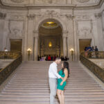 A photo of a couple standing on the Grand Staircase at San Francisco City Hall