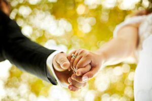 A photo of the hands of a newly married couple with prominent wedding ring