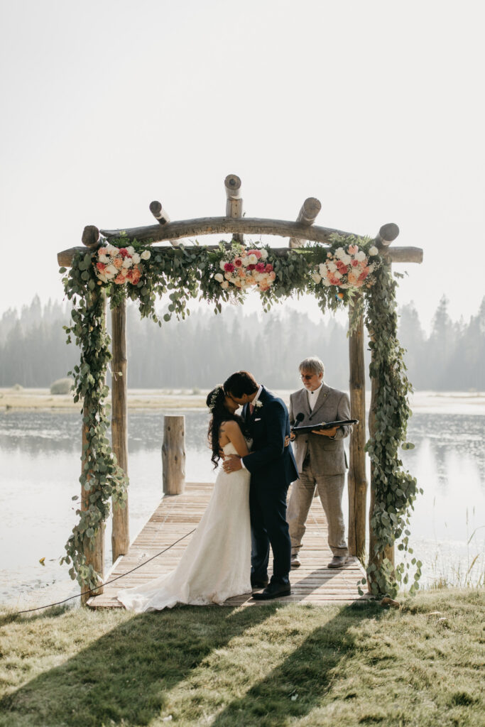 A photo of a couple experiencing their first kiss at their wedding.