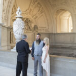 A photo of a couple and their Elopement fourth-floor balcony City Hall