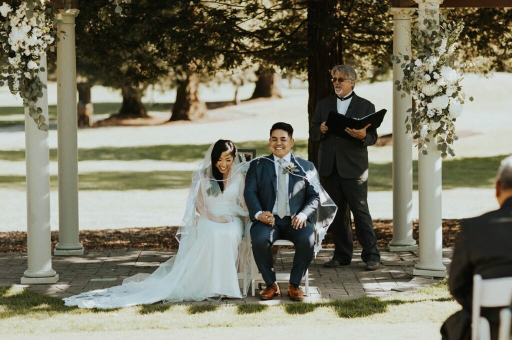 A photo of a couple receiving the cord and veil in a Filipino wedding ceremony the 