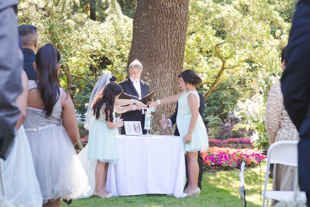 A photo of children participating in the Family Sand Ceremony by pouring sand in the vessel