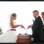 A photo of a couple pouring the sand into the larger vessel during a Unity Sand Ceremony.