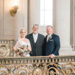 A photo of the Officiant with the couple on the second floor balcony in San Francisco City Hall