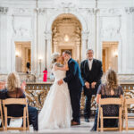 A photo of a couple's First Kiss on the Mayor's Balcony in San Francisco City Hall