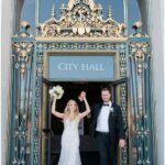 A photo of a couple Bride and Groom Celebrating their wedding at the entrance to San Francisco City Hall